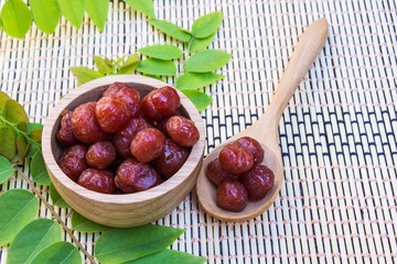 Gooseberry in syrup put in wood bowl and spoon on bamboo wicker, Mayom chueam