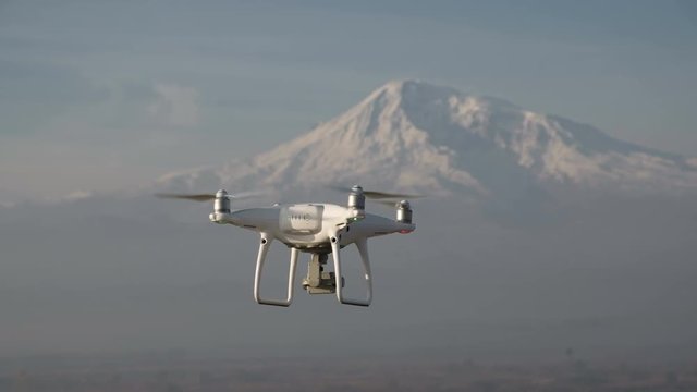 Aircraft copter pilot flight over natural winter scenic place isolated closeup, at background white big cliff ridge. Radio-controlled multirotor helicopter, working by wireless, no people around