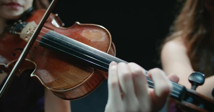 string quartet performs on stage, close-up of violin in work