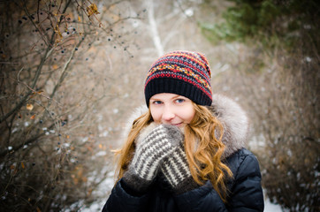 Girl in warm clothes in the winter forest