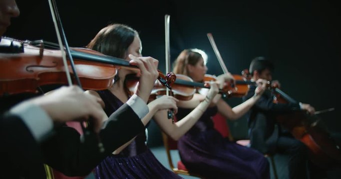 string quartet performs on stage, close-up of violin in work
