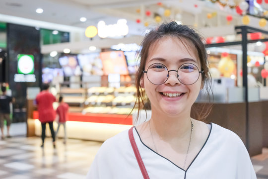 Closeup of young Asian woman with blur shopping mall background.