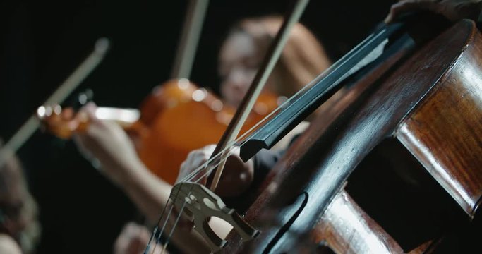 string quartet performs on stage, close-up of a cellist playing