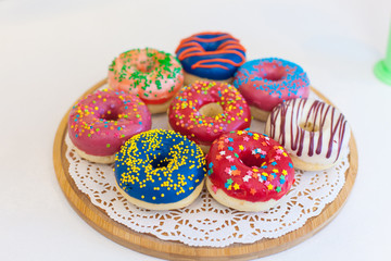 Picture of assorted donuts in a box with chocolate frosted, pink glazed and sprinkles donuts