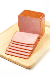 Slices of ham on a wooden board.  