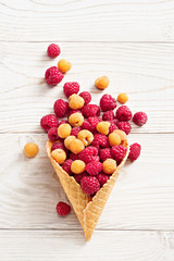 Raspberry explosion. Photo of raspberry in waffle cone on white wooden table. Top view. High resolution product.