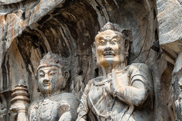 Fototapeta na wymiar Buddhist sculptures in Fengxiangsi Cave, the main one in the Longmen Grottoes in Luoyang, Henan, China. Longmen is one of the 3 major Buddhist caves of China, and a World heritage Site.