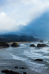 Canon Beach. Oregon Coast. Haystack Rock. Pacific Northwest coastline. Ocean waves. Cloudy sunset. 