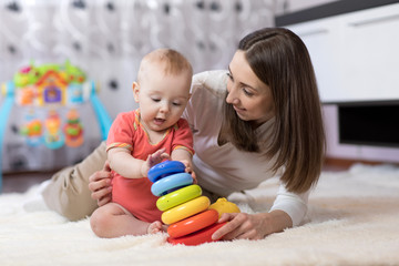 little child boy and his mommy play with toys at home