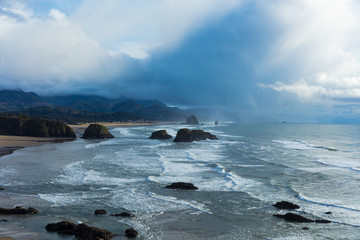 Canon Beach. Oregon Coast. Haystack Rock. Pacific Northwest coastline. Ocean waves. Cloudy sunset. 