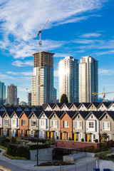 Brand new townhouses in a row on bright sunny day with Highrises in the background.
