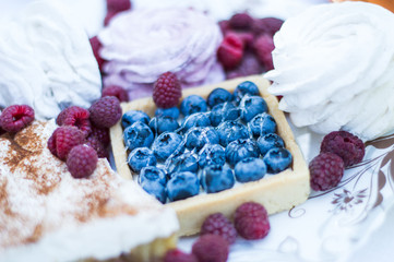 Cake with blueberries on a background of marshmallows and fruits