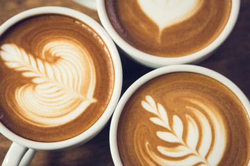 Top view of beautiful latte art coffee, rosetta pattern, in the cups - obrazy, fototapety, plakaty