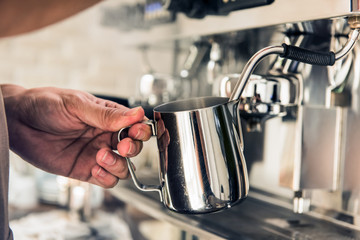 Barista steaming milk with coffee machine