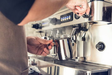 Barista steaming milk with coffee machine