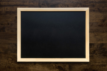 Blank square blackboard on wood background