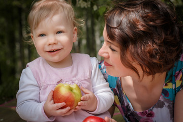 Fototapeta na wymiar Mother and daughter with apple in the hand