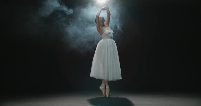4K video footage beautiful elements of classic ballet ballerina dancing on black background, slow motion