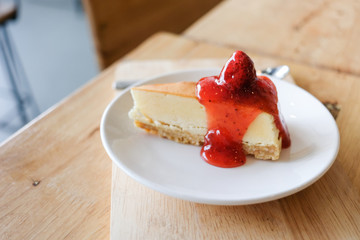 Closeup of cheesecake with strawberry sauce in the cafe.