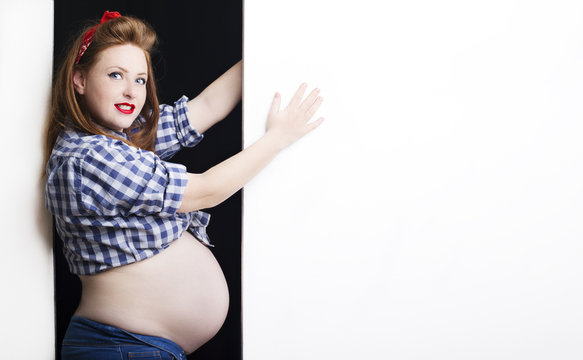 Fashionable redhead pregnant woman in pin up style 