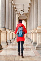 Young traveler woman with backpack in the beautiful colonnade with mineral water in Karlovy Vary...