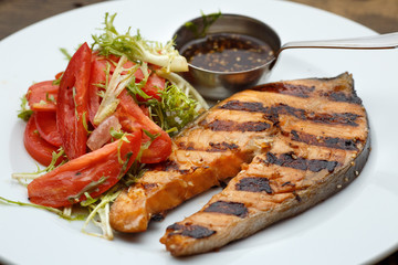 Grilled fish with and salad fresh tomatoes herbs