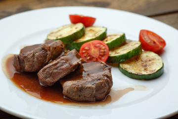 meat medallion drizzled with sauce and zucchini
