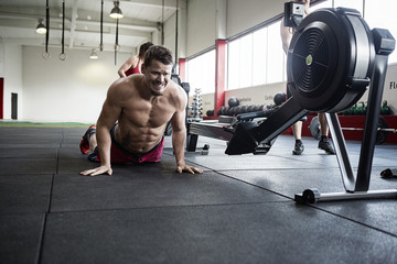 Fototapeta na wymiar Determined Man Practicing Pushups In Gym