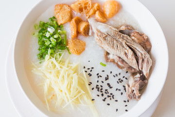 Pork porridge with ginger and coriander in bowl.