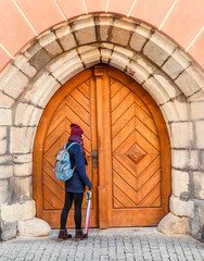 Fototapeta na wymiar The tourist woman at gate of the old castle