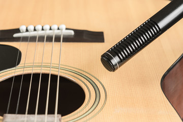 Fototapeta premium soft focus of condenser microphone with blurred acoustic guitar in vintage tone. music and sound record concept.