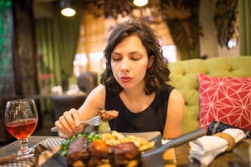Girl eating fried meat in a restaurant