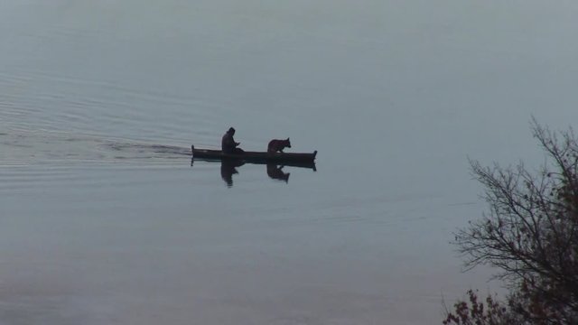 man and a dog in a boat