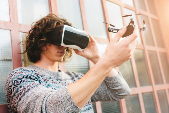 Young man wearing virtual reality glasses and holding a drone