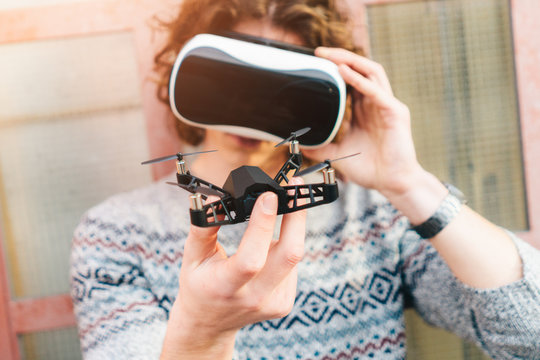Young man wearing virtual reality glasses and holding a drone
