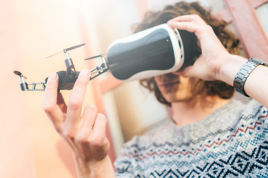 Young man wearing virtual reality glasses and holding a drone