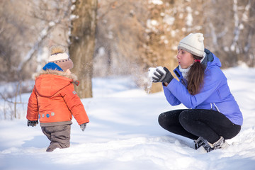 woman with a small child in the park for a winter walk.