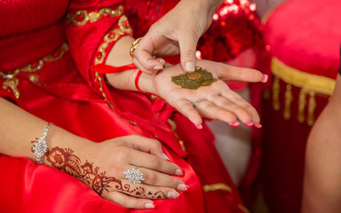 They put their hands henna of the bride . Drawing henna at the Henna party.