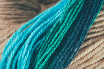 close up view of blue, beige and green knitting yarn