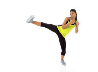 young attractive and furious hispanic sport woman in fight and kick boxing training workout throwing aggressive leg attack isolated
