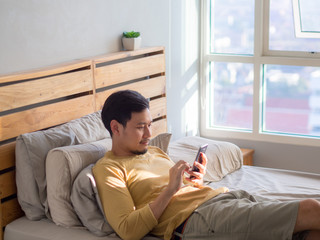 Fototapeta premium Man using smartphone in his bed in the morning.