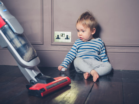 Little boy surprised by vacuum cleaner