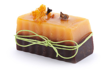 Chocolate orange soap with clove, Illicium, cinnamon and loofah on top isolated on white background
