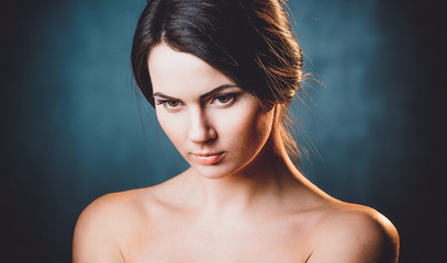 Fototapeta premium Beautiful, young and emotional girl in studio, on a dark background
