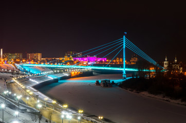 Fototapeta na wymiar Night view of pedestrian bridge over the Tura river in Tyumen