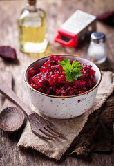 Bowl of beetroot salad on wooden background