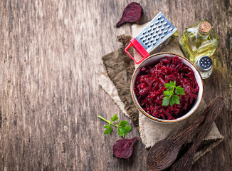 Bowl of beetroot salad on wooden background