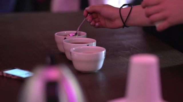 Cropped picture of professional barista assessing quality and taste of espresso in coffee festival close up
