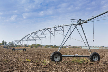 automated farming irrigation sprinklers system on cultivated agricultural landscape field