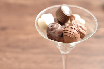 A variety of small chocolates displayed in a martini glass